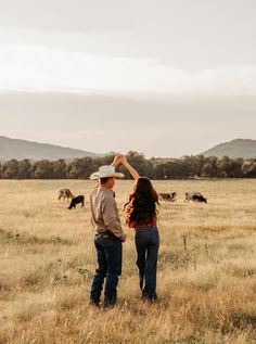 two people standing in the middle of a field