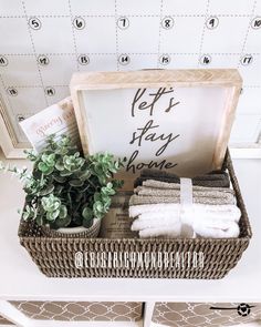 a basket filled with towels and plants on top of a white table next to a calendar