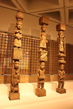 several wooden sculptures on display in a museum