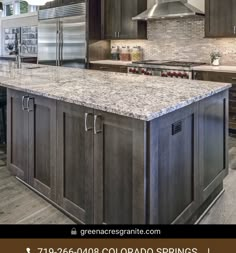 a large kitchen with granite counter tops and stainless steel appliances in the middle of it