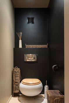 the bathroom is decorated in black and white with an unusual toilet seat that's built into the wall