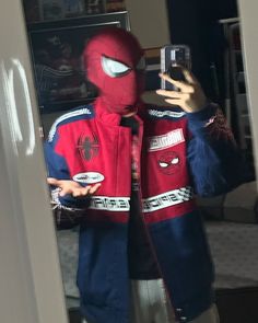 a person wearing a spider man costume taking a selfie