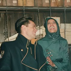 a man and woman are laughing together in an old photo