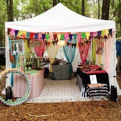 a tent that is set up in the woods for an outdoor party with decorations on it