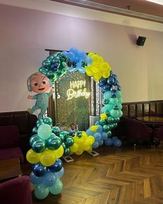 balloon arch in the shape of a monkey with happy birthday sign and balloons on it