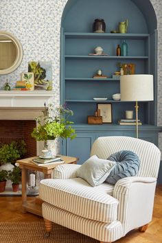 a living room filled with furniture and a fire place next to a wall mounted book shelf