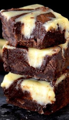 three brownies with white icing stacked on top of each other in front of a black background