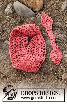 a crocheted bag and spoon laying on the ground with rocks in the background