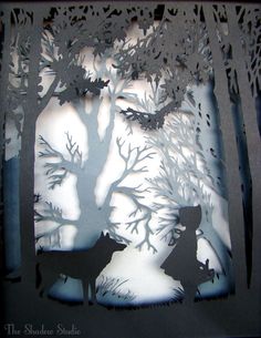 the silhouettes of two animals are shown in this paper cut out scene with trees and birds