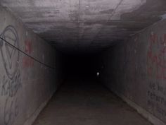 an empty tunnel with graffiti on the walls