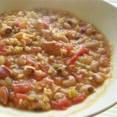 a white bowl filled with beans and meat