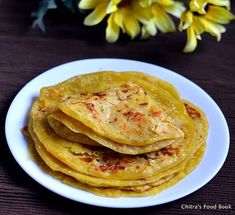 there are some tortillas on the plate and flowers in the vase behind them