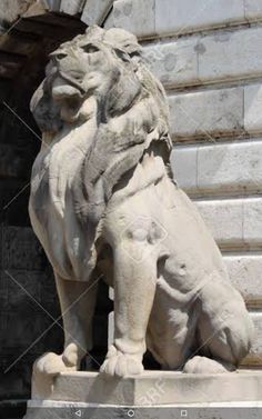 a stone lion statue in front of a building