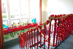 a set of stairs decorated with red flowers and ribbons on the bannister railing