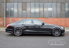 a black car parked in front of a brick building