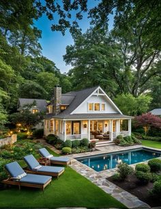 a house with a pool in the yard and lawn furniture next to it, surrounded by trees