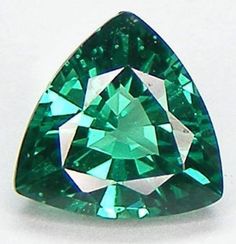 a very pretty green diamond on a white surface