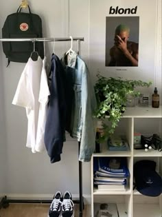 a white shelf with clothes and shoes on it