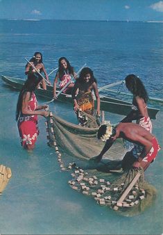 some people are standing in the water near a boat with a long net on it