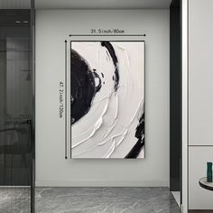 a black and white painting hanging on the wall