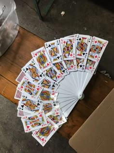 playing cards laid out on a wooden table in front of a box and some other items