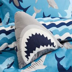 a bed with shark pillows and blue sheets