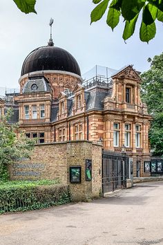 an old building with a dome on top and fenced in area next to it