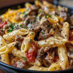 a bowl full of pasta with mushrooms, tomatoes and parmesan cheese on top