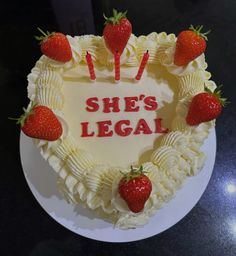 a heart shaped cake that says she's legal with strawberries on the top