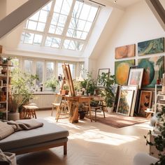 a living room filled with lots of furniture and paintings on the wall next to a window