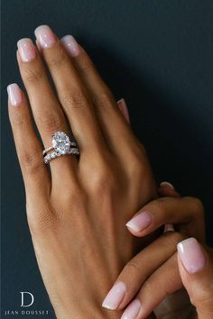 a woman's hand with two rings on her fingers and one holding the other