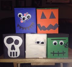 four halloween bags sitting on top of a table with faces and eyes painted on them