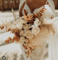 a woman in a white dress holding a bouquet of flowers and feathers on her wedding day