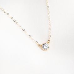 Our Solitaire Necklace is classic and sophisticated. Simple enough to wear everyday, yet elegant enough to wear out on the town! The gem has a stunning burst of glimmer when it catches the light. We love it paired with our Herringbone Necklace! DETAILS Necklace length: 16" with 2" extender 6mm cubic zirconia stone Gold filled -or- sterling silver bezel, chain, & findings Matching ring: Gold Solitaire Ring Floating Diamond Necklace, Dainty Diamond Necklace, Floating Necklace, Pearl Chain Necklace, Solitaire Necklace, Detailed Necklace, Gold Solitaire Ring, Herringbone Necklace, Necklace Bridal