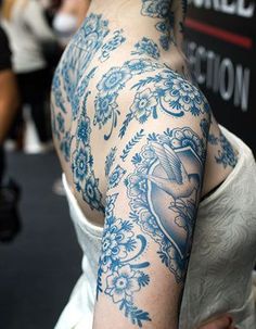 a woman with tattoos on her arm and shoulder