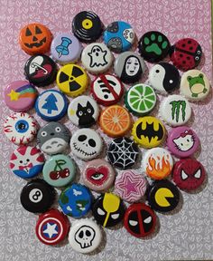 a pile of buttons with different designs on them sitting on top of a pink table cloth