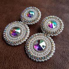 three pairs of beaded earrings on a brown surface