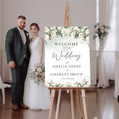 a couple standing next to each other in front of a welcome sign for their wedding