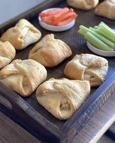 several pastries are on a tray with carrots, celery and celery sticks