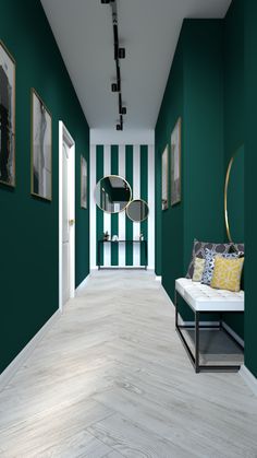 an empty room with green and white stripes on the walls, two mirrors hanging from the ceiling