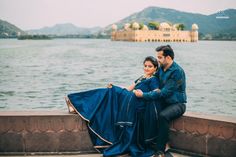 a man and woman sitting next to each other near the water