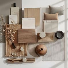 an arrangement of wood, paper and other items arranged on a white surface with sunlight coming through the window