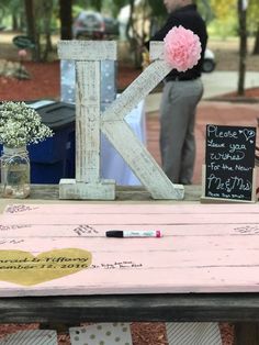 a table that has some writing on it and flowers in vases next to it