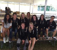 a group of people sitting next to each other under a tent