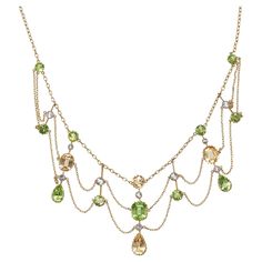 An antique, peridot, citrine, white sapphire and gold festoon necklace, with round, cushion and drop shaped faceted peridots and citrines, in gallery claw settings, and white sapphires, in millegrain edged rub over settings, in knife edge pendants, on a trace chain, with finer, trace chain festoons, with a barrel clasp, engraved with 15, for 15ct gold, with inventory number a8609 scratched on a pendant, circa 1890. Approximate Measurements: Length 388mm, longest drop 39mm Festoon Necklace Vintage, Festoon Necklace, Peridot Necklace, Round Cushion, Antique Necklace, Antique Diamond, Victorian Jewelry, Necklace Vintage, Love Ring