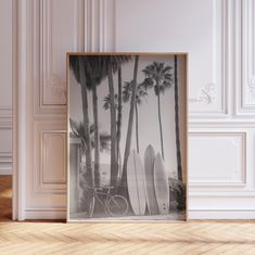 there is a framed photo with surfboards in front of palm trees and a bicycle