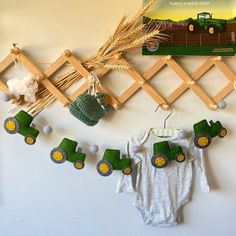 a baby's bodysuit hanging from a clothes line with farm animals on it