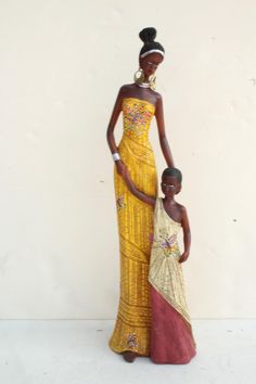 a woman and child are standing next to each other in front of a white wall