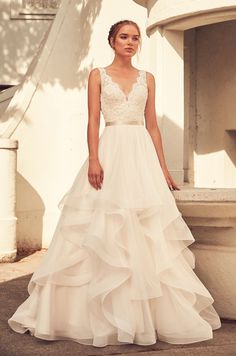 a woman in a wedding dress standing outside