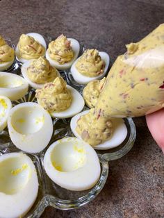 someone is spreading deviled eggs with mayonnaise and mustard on them to make deviled eggs